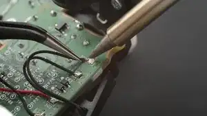 Erhitze die Lötstelle an einem der Motorkontakte.