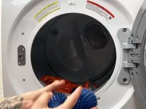 Füge 2-3 Trocknerbälle, saubere Tennisbälle oder zu Bällchen gerollte Socken dazu.