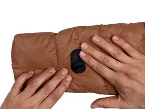 Eine gefüllte Jacke mit Reparaturklebeband flicken