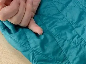 Eine lose Nahtschlinge an einer Regenjacke reparieren