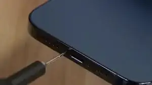 To begin the screen replacement process, start by removing the two screws located at the bottom of the device on either side of the charging port. Use a P2 Pentalobe screwdriver to complete this step.