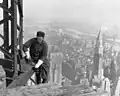 Ein Bauarbeiter in den USA, vor fast hundert Jahren. Er arbeitet an einem Hochhaus.