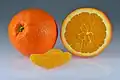 Eine ganze und eine aufgeschnittene Orange