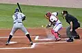 Baseball: in schwarz der Schiedsrichter, der urteilt, wie der Ball geworfen wurde.