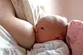 Dieses Baby trinkt Milch an den Brüsten seiner Mutter.