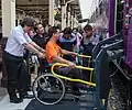 Dieser Zug hat eine Plattform, die angehoben werden kann. So kommt auch jemand im Rollstuhl in den Zug.