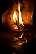 Eine Kerzenflamme. Das Flüssige unten im Bild ist Wachs.
