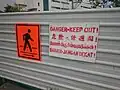 Ein Warnschild in den vier Amtssprachen des Landes: Englisch, Chinesisch, Tamil und Malayisch.