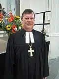 Der evangelische Bischof aus Deutschland unterscheidet sich vom Pfarrer nur durch das Kreuz auf der Brust.