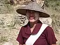 Eine Frau aus Myanmar mit Sonnenhut und im Gesicht mit Paste aus Baumrinde.
