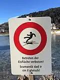 Ein Schild in zwei Sprachen: „Betreten der Eisfläche verboten!“ - „Scumandà dad ir sin il glatsch!“