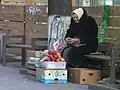Eine Frau verkauft Äpfel am Straßenrand.