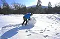 Hier rollt jemand eine Schneekugel für einen Schneemann oder eine Schneefrau.