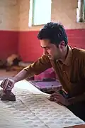 Ein Handwerker und Künstler in Indien druckt mit Stempeln, wie man es früher gemacht hat.