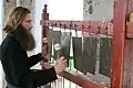 Ein russisch-orthodoxer Mönch spielt ein Semantron, ein Schlagbrett, mit dem man zum Gebet ruft.