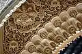 Aus Mörtel geformte und bemalte Ornamente unter einem Bogen im Palast der Alhambra.