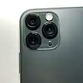 Ein Smartphone: das iPhone von Apple. Hier auf der Rückseite sieht man drei verschiedene Objektive und ein kleines Licht.