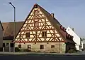 Auch das Fachwerkhaus hat seine Festigkeit wegen der Dreiecke.