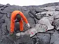 Dieser Vulkanologe nimmt eine Lava-Probe, um sie zu untersuchen.
