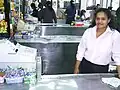 Die Kassiererin an der Kasse leistet Arbeit.