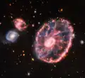 Die Wagenrad-Galaxie sieht wohl so aus, weil eine kleinere Galaxie dagegen gestoßen ist.