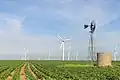 Ein altes Windrad in Texas. Im Hintergrund sieht man eine moderne Windkraftanlage.