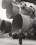 Hier sieht man Wernher von Braun, einen bekannten Raketeningenieur, vor den Triebwerken der Saturn-V-Rakete