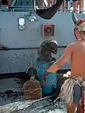 Ein Mann wurde bei der Äquatortaufe in ein Fass gesteckt. Der andere Mann hat sich verkleidet.