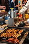 Eine Currywurst-Schneidemaschine. Die Wurst liegt schon unten im Teller.
