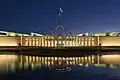 Das Parlament in Canberra spiegelt sich im Wasser.