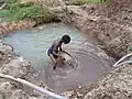 Dieser Mann in Sri Lanka versucht Edelsteine im Schlamm zu finden.