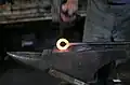 Ein heißes Stück Metall, das in einer Schmiede geschmiedet wird