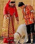 Braut und Bräutigam in traditionaller Kleidung für eine Hochzeit, mit Alabay-Hund