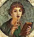 Ein Gemälde aus Pompeji: Diese Römerin hält in der einen Hand einen Griffel zum Schreiben und in der anderen Hand eine Wachstafel.