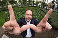 Jimmy Wales macht hier das Wikipedia-Zeichen.