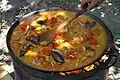 Hier macht man eine Paella, mit Garnelen, Muscheln und Limetten.