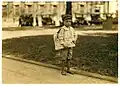 Der siebenjährige Lewis in einer amerikanischen Stadt, im Jahr 1914. Er muss bereits Zeitungen verkaufen.