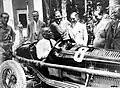 Mussolini in einem Rennwagen. Der Mann direkt hinter ihm ist Enzo Ferrari, der Gründer der Automarke Ferrari.