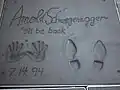 An anderer Stelle sind Hand- und Schuhabdrücke sowie Autogramme von Stars in Beton. Hier: Arnold Schwarzenegger.