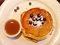Amerikanische Pancakes isst man mit Ahornsirup und Beeren.