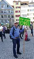 Dieser Großvater hat ein Schild auf einer Demo für das Klima: „Für unsere Enkel“.