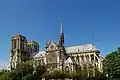 Rechts an der Kathedrale Notre-Dame in Paris erkennt man die senkrechten Strebepfeiler und die schrägen Strebebögen. Das riesige runde Fenster in der Mitte besteht aus Maßwerk und farbigen Scheiben