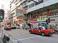 Eine Straße in Hongkong, einer Stadt im Süden von China. Die Aufschriften an den Häusern sind in chinesischer Schrift.