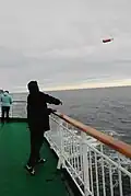 Auf einer Fahrt entlang der norwegischen Küste: Jemand wirft eine Flasche über Bord.
