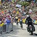 In den Bergen gibt es besonders viele Zuschauer. Von Motorrädern aus wird für das Fernsehen gefilmt.
