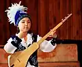 Ein Mädchen spielt das Instrument „Komuz“.