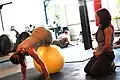 Diese Trainerin beobachtet, wie eine Frau sich auf dem Gymnastikball bewegt.