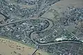 Ein Luftbild von einer japanischen Stadt im Jahr 2019. Man erkennt in Braun die überfluteten Gebiete.