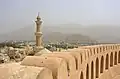 Die alte Nizwa-Festung mit dem Minarett der Freitagsmoschee in Oman