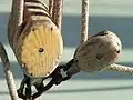 Die beweglichen Rollen eines älteren Flaschenzugs aus Holz